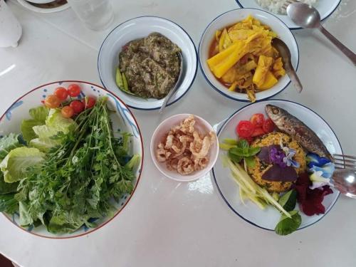 a table with four plates of food on it at PANAKLUEA Cottage & Crafts - พนาเกลือ in Ban Kham