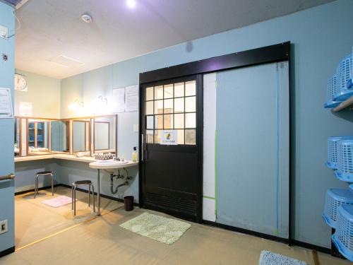 a bathroom with a black door and a sink at Hotel Hanagesiki in Ukiha