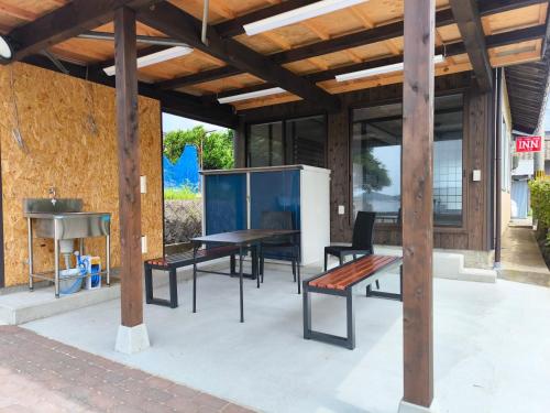 a patio with a table and chairs and a grill at INN Kumihama 丹後 一棟貸し 海の宿 INN久美浜 in Kyotango