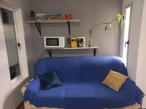 Un sofá azul en una habitación con microondas. en El Cardiel, en Gobernador Gregores