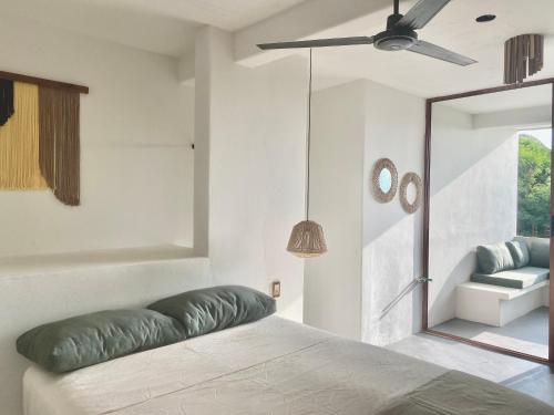 a bedroom with a bed and a ceiling fan at Kasa Koh in Brisas de Zicatela