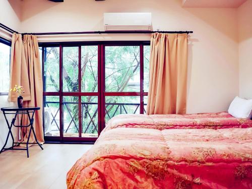 a bedroom with a bed and a large window at ゲストハウス清水京湖 in Gionmachi