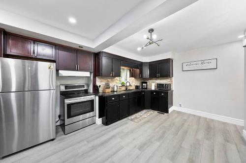 a kitchen with black cabinets and a stainless steel refrigerator at Charming Cozy 2-Bedroom Retreat in South Windsor in Windsor