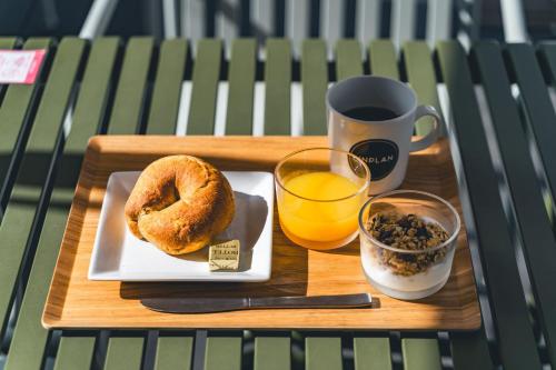 a tray with a plate of donuts and a cup of orange juice at UNPLAN Kagurazaka in Tokyo