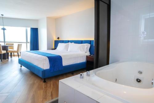 a hotel room with a bed and a bath tub at Wyndham Guayaquil, Puerto Santa Ana in Guayaquil