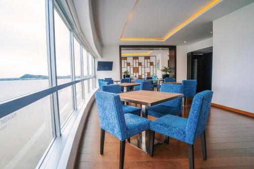 a dining room with blue chairs and a table at Wyndham Guayaquil, Puerto Santa Ana in Guayaquil