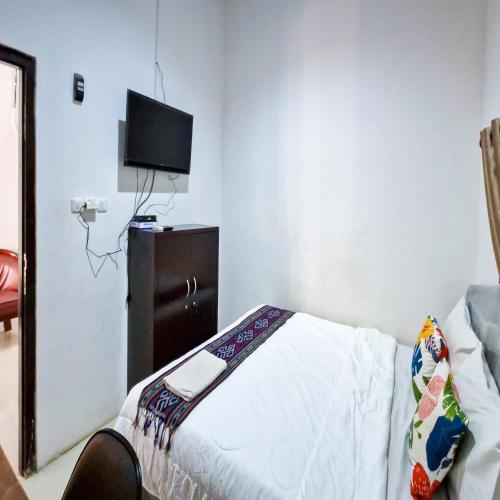 a bedroom with a bed and a tv on the wall at TNC Residence Syariah Mataram in Mataram