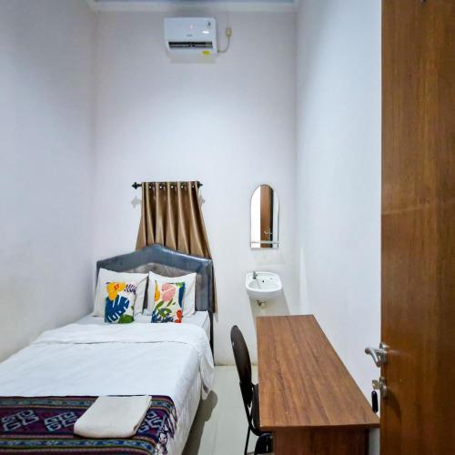 a small room with a bed and a table at TNC Residence Syariah Mataram in Mataram