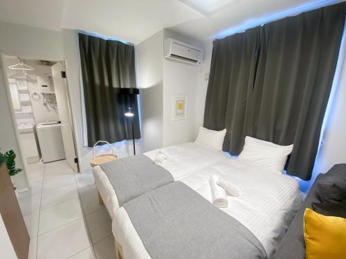 a bedroom with a bed with white shoes on it at EFFECT Kikusui in Sapporo
