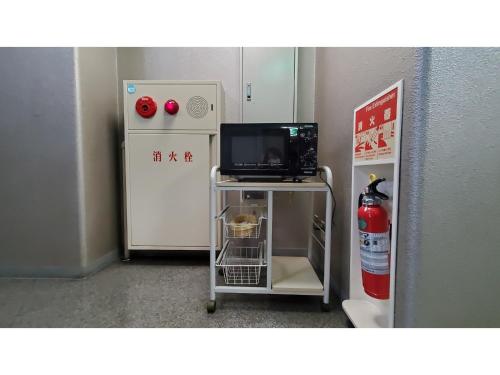 a room with a refrigerator and a television on a cart at Nobeoka Urban-Hotel - Vacation STAY 30462v in Nobeoka