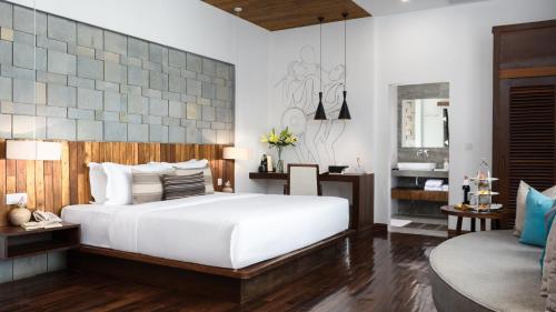 a bedroom with a large white bed and a couch at Shintana Saya Residence in Siem Reap