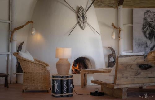 a living room with a table and a fireplace at Mara Major Camp in Masai Mara