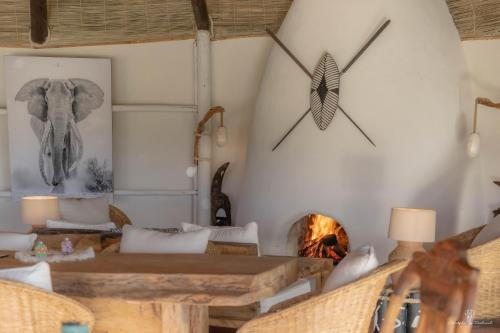 a living room with an elephant clock on the wall at Mara Major Camp in Masai Mara
