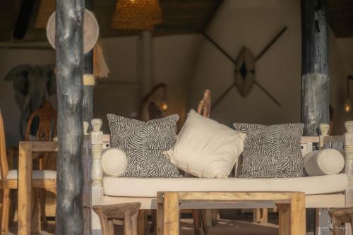 a couch with pillows on it in a room at Mara Major Camp in Masai Mara