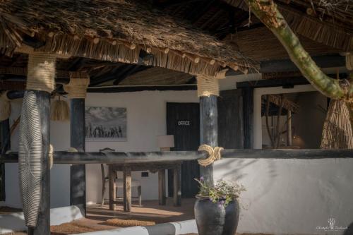a building with a table and a straw roof at Mara Major Camp in Masai Mara