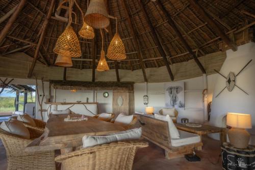 a living room with a couch and a table and chairs at Mara Major Camp in Masai Mara