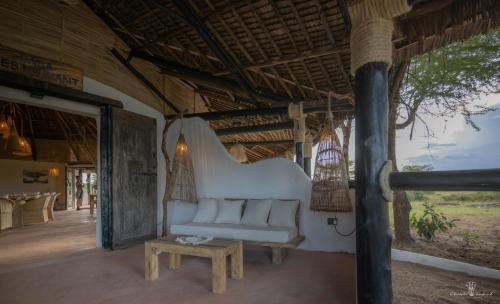 a living room with a white couch and a table at Mara Major Camp in Masai Mara