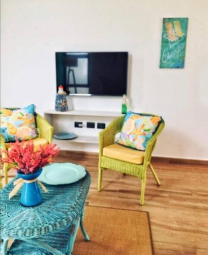 a living room with two chairs and a table at Villa Nicte ha - Antalea in Telchac Puerto