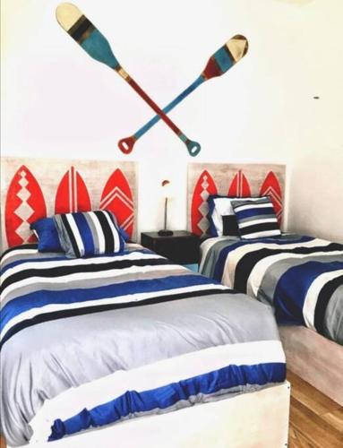 a bedroom with two beds with oars on the wall at Villa Nicte ha - Antalea in Telchac Puerto