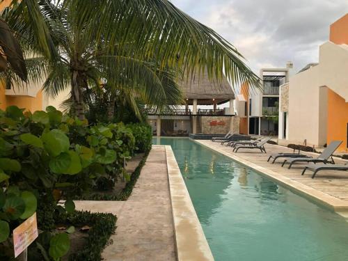 a swimming pool with chaise lounges and a resort at Villa Nicte ha - Antalea in Telchac Puerto