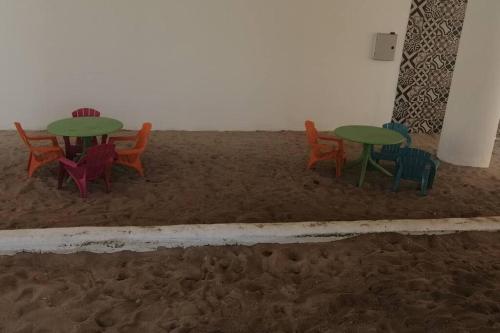 four tables and chairs sitting in the sand at Villa Nicte ha - Antalea in Telchac Puerto
