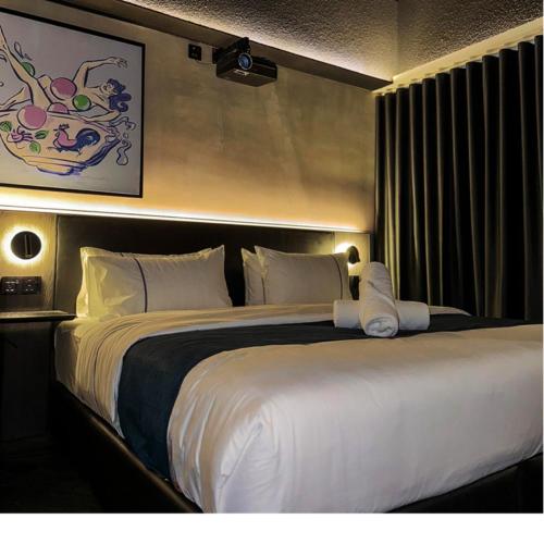 a bedroom with a large bed with white sheets at B Hotel Kuala Lumpur in Kuala Lumpur