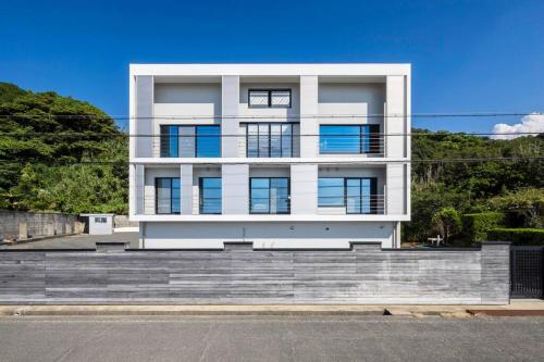 a white building with stairs in front of it at 野辺崎の風 Nobezaki no kaze in Itoshima