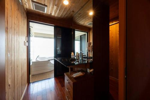 a bathroom with a sink and a large window at 野辺崎の風 Nobezaki no kaze in Itoshima