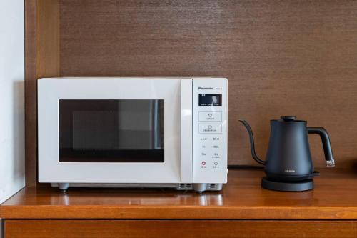a microwave sitting on top of a wooden table at 野辺崎の風 Nobezaki no kaze in Itoshima