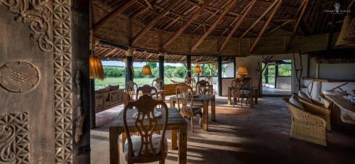 a dining room with tables and chairs in a building at Mara Major Camp in Masai Mara