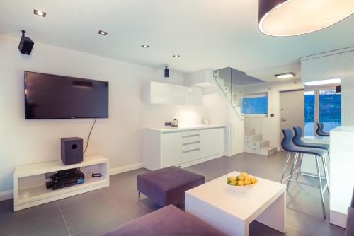 a living room with a tv and a table at Lemon Resort Spa in Gródek Nad Dunajcem
