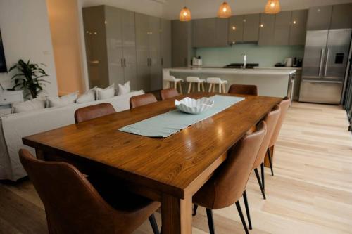 a dining room table with chairs and a living room at Vida Hamilton - 3 bed, 2 bath kids playground! in Hamilton