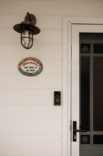 a sign on the side of a house with a door at Vida Hamilton - 3 bed, 2 bath kids playground! in Hamilton