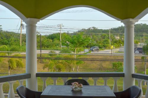 a table on a porch with a view of train tracks at Veronica Homestay Lucea Jamaica in Lucea