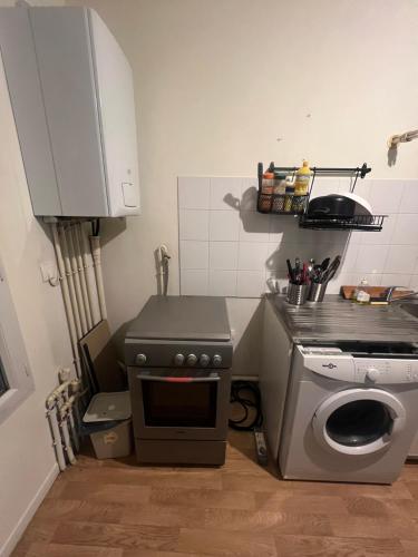 une cuisine avec une cuisinière et une machine à laver dans l'établissement Charmant studio à Gonesse, à Gonesse
