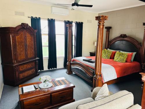 a bedroom with a large bed and a couch at Flinders Ranges Motel - The Mill in Quorn