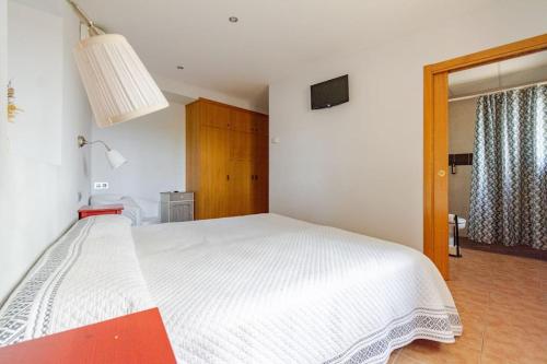 a bedroom with a white bed and a window at Casa Rural Torre Gil in Alcañiz