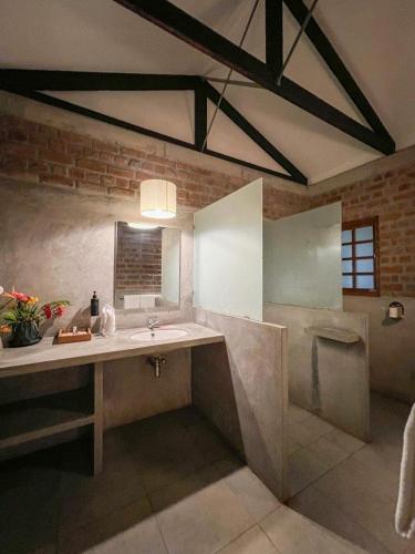 a large bathroom with a sink and a shower at Mango Hill Auroville Pondicherry in Pondicherry
