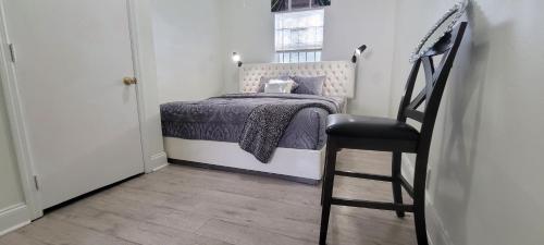 a small bedroom with a bed and a chair at Large, Central, Lovely & Cozy 4bed/2bath - House by Everbank Stadium JACKSONVILLE in Jacksonville