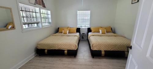 two beds in a small room with two windows at Large, Central, Lovely & Cozy 4bed/2bath - House by Everbank Stadium JACKSONVILLE in Jacksonville