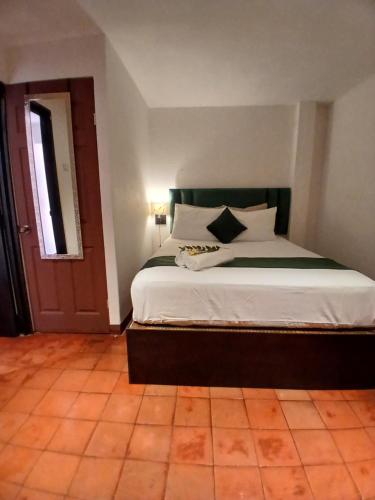 a bedroom with a large bed with white sheets at Hotel La Xinca in Antigua Guatemala