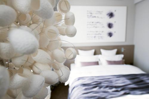 a bedroom with a bed and a wall covered in white spheres at Hotel Cubo in Ljubljana