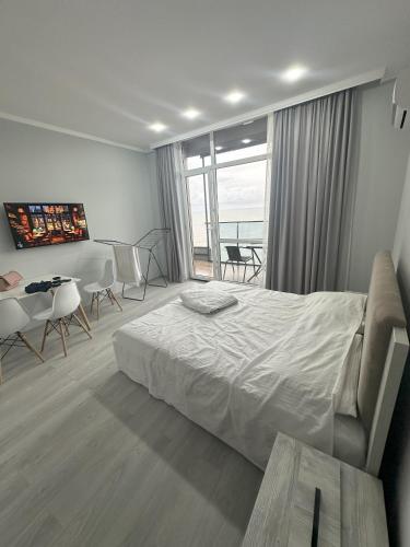 a hotel room with a bed and a table and chairs at Bi Residence Sea View luxury Batumi in Batumi