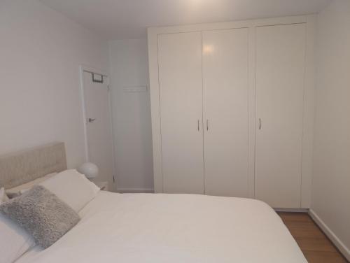 1 dormitorio blanco con armarios blancos y 1 cama en Ground Floor Elwood village Apartment, en Melbourne