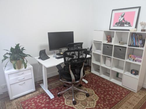 una oficina con un escritorio con una computadora y una silla en Ground Floor Elwood village Apartment, en Melbourne