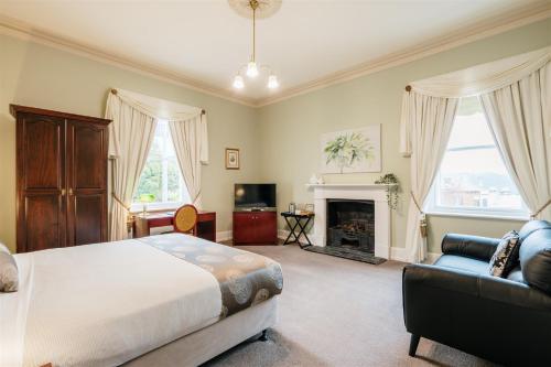 a bedroom with a bed and a couch and a fireplace at Waratah On York in Launceston