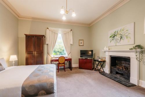 a bedroom with a bed and a fireplace at Waratah On York in Launceston