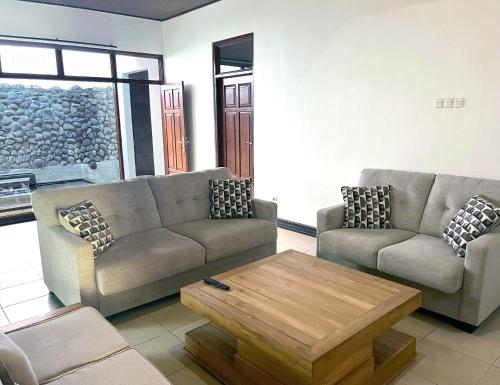 a living room with two couches and a coffee table at Eimas Hive in Kerobokan