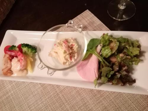 a plate of food with a salad and a glass dish at Pension Pure in Iiyama