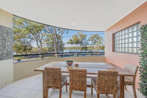 a dining room with a table and chairs on a balcony at Pippies your water view escape in North Haven